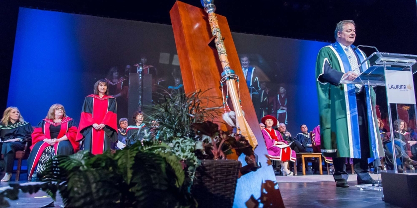 Dr. Maria Cantalini-Williams on stage with mace and president