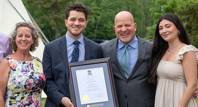 Family with graduate holding degree frame