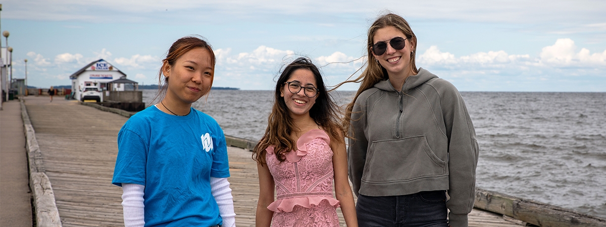 3 students on the dock at the waterfront