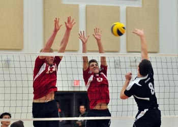 Photo of volleyball players blocking at the net