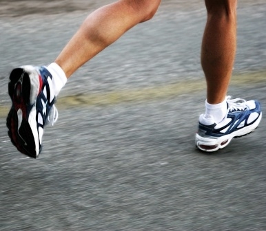 Photo of lower legs in mid stride with running shoes
