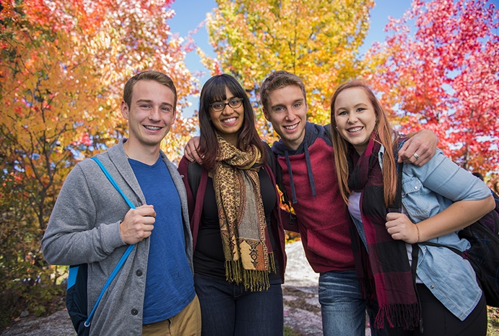 Photo of Nipissing students in front of gorgeous fall colour trees