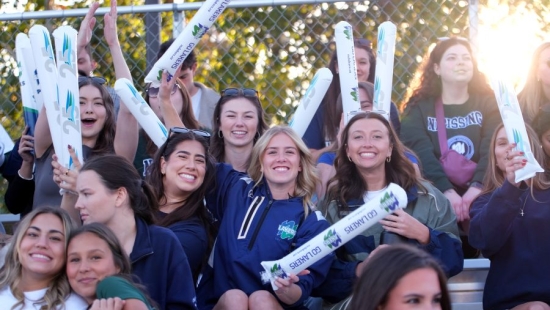 Lakers cheering during games with thunder sticks raised high in the air