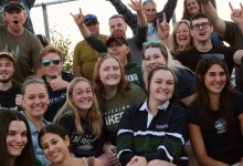 Homecoming attendees cheering from the bleachers