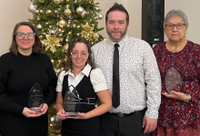 VAWCC Award Recipients stand in front of a holiday tree. 