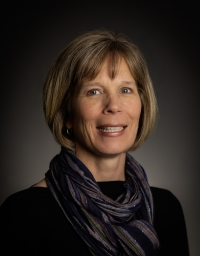 Woman in scarf smiling at camera